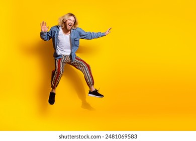 Full length photo of handsome young male fly keep balance surfing dressed stylish denim garment isolated on yellow color background - Powered by Shutterstock