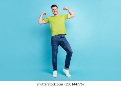 Full length photo of happy positive young man flex muscles biceps isolated on pastel blue color background