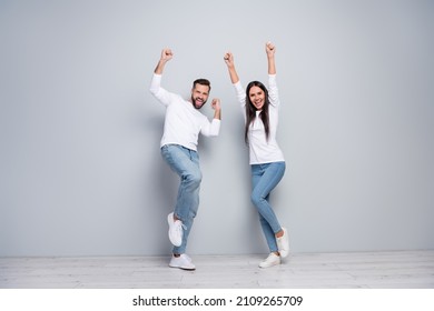 Full length photo of hooray young couple yell wear shirt jeans sneakers isolated concrete grey color wall background