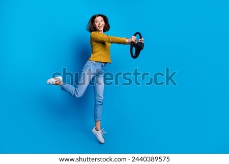 Full length photo of impressed funky woman wear shirt jumping high riding auto empty space isolated blue color background