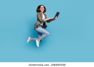 Full length photo of lady it developer jump use device online discount wear denim jeans shirt isolated over blue color background