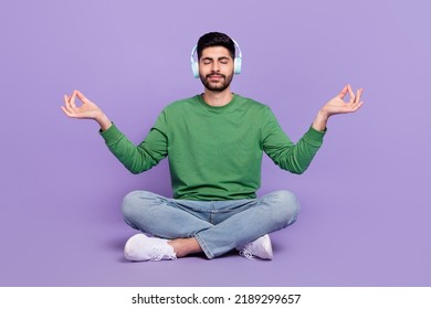 Full length photo of latin arab guy meditate listen classical music lotus pose wear stylish green look isolated on purple color background - Powered by Shutterstock