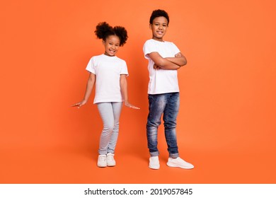 Full length photo of little cool girl boy crossed arms wear white t-shirt jeans sneakers isolated on orange background - Powered by Shutterstock