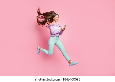 Full length photo of lovely teenager lady dressed casual clothes holding looking modern device isolated pastel pink color background - Powered by Shutterstock