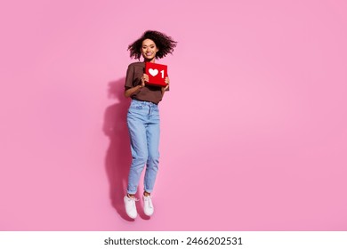 Full length photo of lovely young lady jump hold heart icon dressed stylish brown garment isolated on pink color background - Powered by Shutterstock