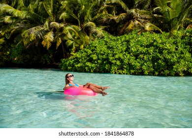 Full length photo of luxury lady tourist enjoy relax exotic paradise island swim azure aqua water life buoy sun bath wear blue body suit