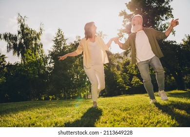 Full Length Photo Of Mature Couple Hold Hands Romantic Forest Go Run Green Grass Nature Spring Outdoors