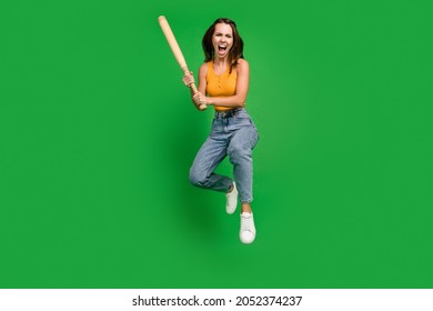 Full length photo of millennial angry brunette lady jump wear top jeans sneakers isolated on green background