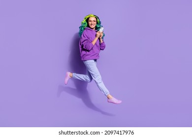 Full length photo of millennial youngster lady with vivid haircut jump up use app smart-phone isolated over purple color background