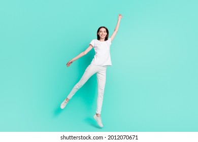 Full length photo of nice brunette hair millennial lady jump wear white t-shirt jeans isolated on teal color background - Shutterstock ID 2012070671