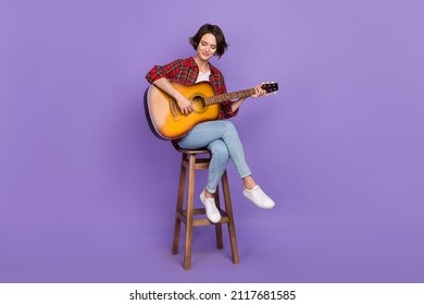 Full length photo of nice millennial brunette lady play guitar wear shirt jeans sneakers isolated on purple color background - Powered by Shutterstock
