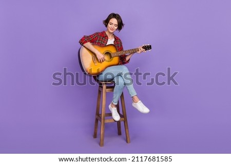 Full length photo of nice millennial brunette lady play guitar wear shirt jeans sneakers isolated on purple color background