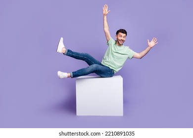 Full Length Photo Of Nice Young Guy Sit White Cube Copyspace Falling Back Wear Trendy Gray Clothes Isolated On Violet Color Background