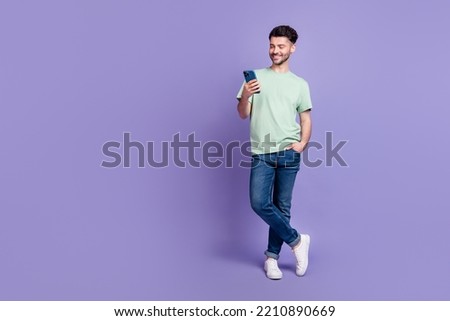 Full length photo of nice young guy hold gadget apple samsung google user wear trendy gray clothes isolated on violet color background