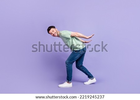Full length photo of nice young man carry empty space back toothy smile dressed stylish gray garment isolated on purple color background