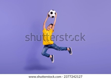 Full length photo of nice young pupil boy jumping catch ball goalkeeper dressed yellow garment isolated on violet color background