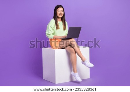 Full length photo of optimistic adorable smart girl wear stylish pullover sit on platform with laptop isolated on violet color background