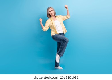 Full length photo of overjoyed glad person raise fists attainment accomplishment isolated on blue color background - Shutterstock ID 2368101081
