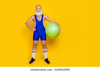 Full length photo of posing funny grandfather hold green acrobatic ball nice sportsman empty space promo equipment isolated on yellow color background