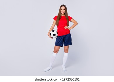 Full length photo positive cheerful footballer girl hold foot ball ready play world final championship soccer tournament wear red t-shirt blue shorts shoes isolated grey color background - Powered by Shutterstock