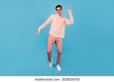Full length photo of positive cheerful happy man dance good mood wear sunglasss isolated on blue color background