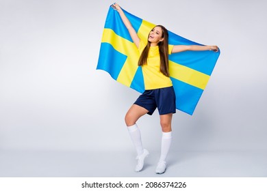 Full Length Photo Of Positive Cheerful Girl Hold Swedish Flag Support Her Country Team Uefa World Cup Match Champion Wear Football Kit Shoes Isolated Over Grey Color Background