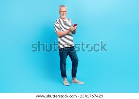 Full length photo of positive grandfather dressed trendy clothes use modern device read post isolated on blue color background