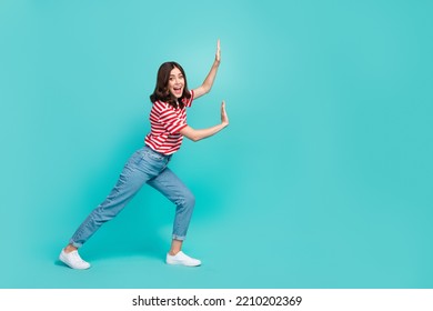 Full length photo of positive lady hold empty space push imaginary stone large product isolated on aquamarine color background - Shutterstock ID 2210202369