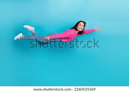 Full length photo of pretty confident woman dressed pink sweater flying sky fast isolated blue color background