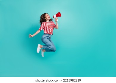 Full length photo of pretty cute girl dressed red t-shirt jumping high shouting bullhorn empty space isolated teal color background - Powered by Shutterstock