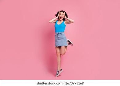 Full length photo of pretty funny crazy lady jump high up arms on head look sale black friday advert wear blue tank-top denim short skirt shiny footwear isolated pink color background