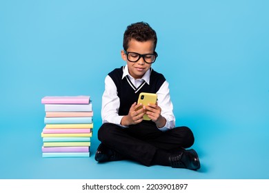 Full Length Photo Of Pretty Funny Little Guy Dressed Black Vest Typing Modern Gadget Reading Book Isolated Blue Color Background