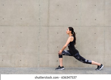 Full Length Photo Of Pretty Sporty Young Woman Warm Up Stretching Legs Before Morning Running Workout Outdoor On Gray Wall Background City Building Walkway.