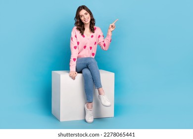 Full length photo of pretty sweet lady dressed pink cardigan smiling pointing emtpy space isolated blue color background - Powered by Shutterstock