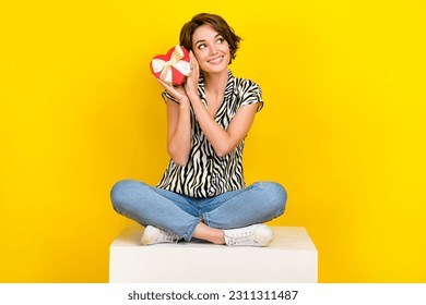 Full length photo of pretty thoughtful lady wear animal print shirt holding heart box looking empty space isolated yellow color background - Shutterstock ID 2311311487