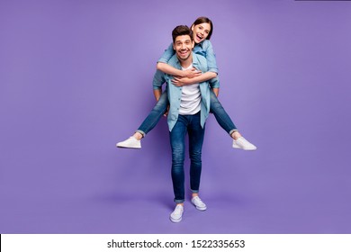 Full length photo of romantic funny funky married people have fun date hug piggyback  enjoy date wear stylish trendy clothes isolated over purple color background