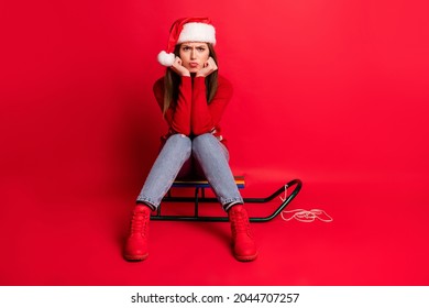 Full length photo of sad millennial lady sit wear sweater cap jeans boots isolated on red color background - Powered by Shutterstock