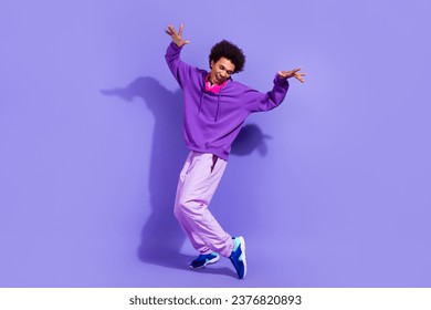 Full length photo of satisfied pleasant guy dressed violet hoodie stylish sportswear dancing fooling isolated on purple color background - Shutterstock ID 2376820893