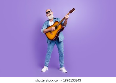 Full length photo of senior man happy positive smile play guitar sing isolated over violet color background - Powered by Shutterstock