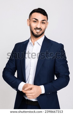 Full length photo of serious delighted concentrated turkish man looking at camera smiling wearing smart ellegant suit standing over grey background in studio isolated. Stock photo © 
