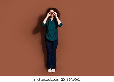 Full length photo of shiny attractive lady dressed formal shirt looking you binoculars empty space isolated brown color background - Powered by Shutterstock