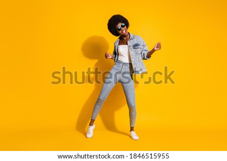Full length photo of shiny lovely young lady wear casual denim outfit smiling dancing isolated yellow color background Foto stock © 