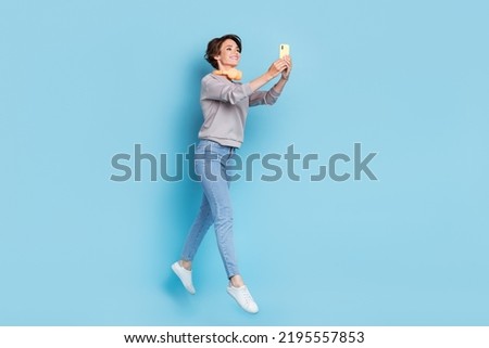 Full length photo of short hairdo millennial lady jump wear headphones shirt jeans shoes isolated on blue color background