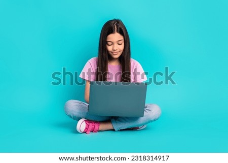 Full length photo of small kid brunette hair sitting studying netbook remote online education courses isolated on aquamarine background