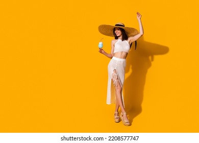 Full length photo of stunning carefree lady wear white outfit hat having fun enjoying blue cocktail empty space isolated yellow color background - Powered by Shutterstock