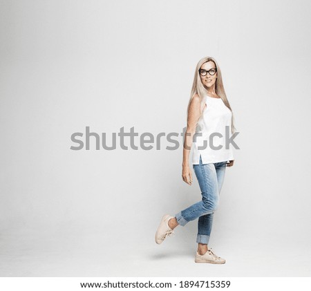 Image, Stock Photo Full body portrait of a young woman standing barefoot with long legs in a leopard print top and hot pants against a concrete wall looking challengingly at the camera