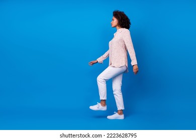 Full length photo of sweet adorable girl dressed pink blouse walking up empty space isolated blue color background - Powered by Shutterstock