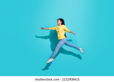 Full length photo of sweet cute lady dressed yellow sweater jumping running empty space isolated turquoise color background