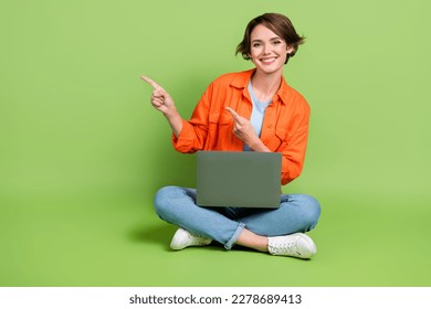Full length photo of sweet cute lady dressed jeans shirt working modern gadget emtpy space isolated green color background