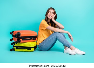 Full length photo of sweet dreamy lady wear yellow t-shirt looking empty space packing suitcases isolated turquoise color background